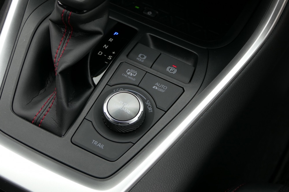 内装におけるPHVの識別点は、2つの走行モードの切替スイッチ。HV/EV/チャージの選択ボタン、もう1つはAUTOモード用ボタン。