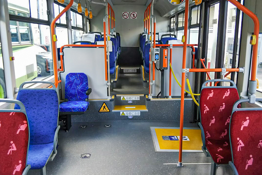 典型的なノンステップバスの内装。つり革や手すり、停車ボタンもまんま日本の路線バス仕様に架装されている。