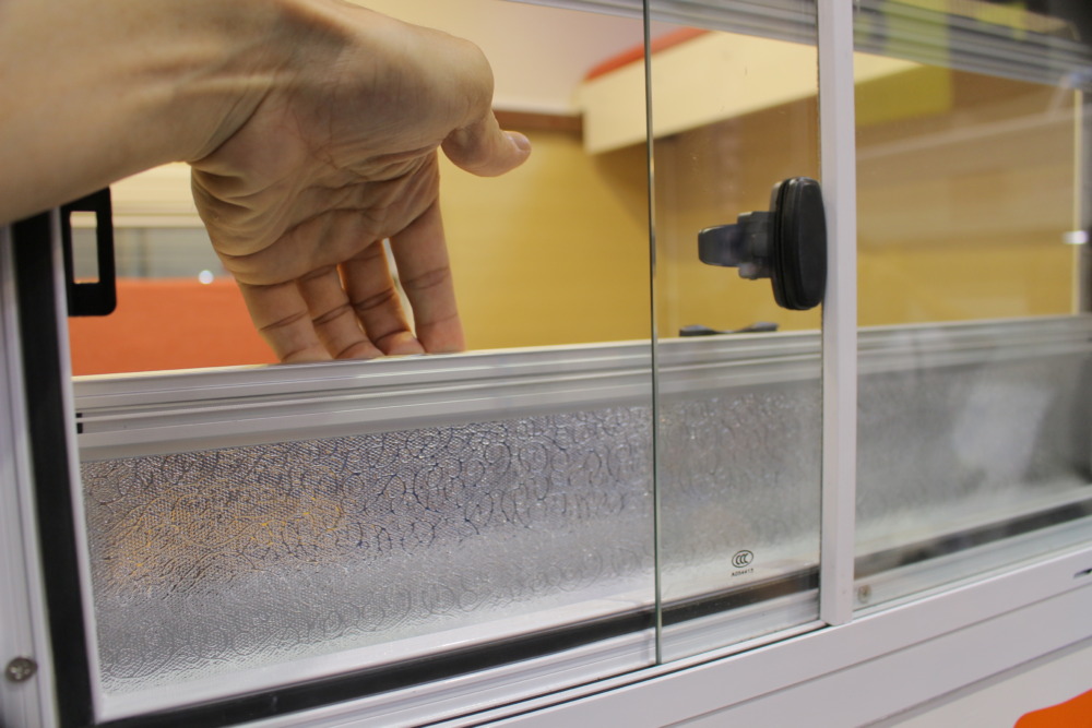 スライドガラス式の窓は、下部からシェードを引き出すことができ、上部から網戸を引き下ろすことができる。