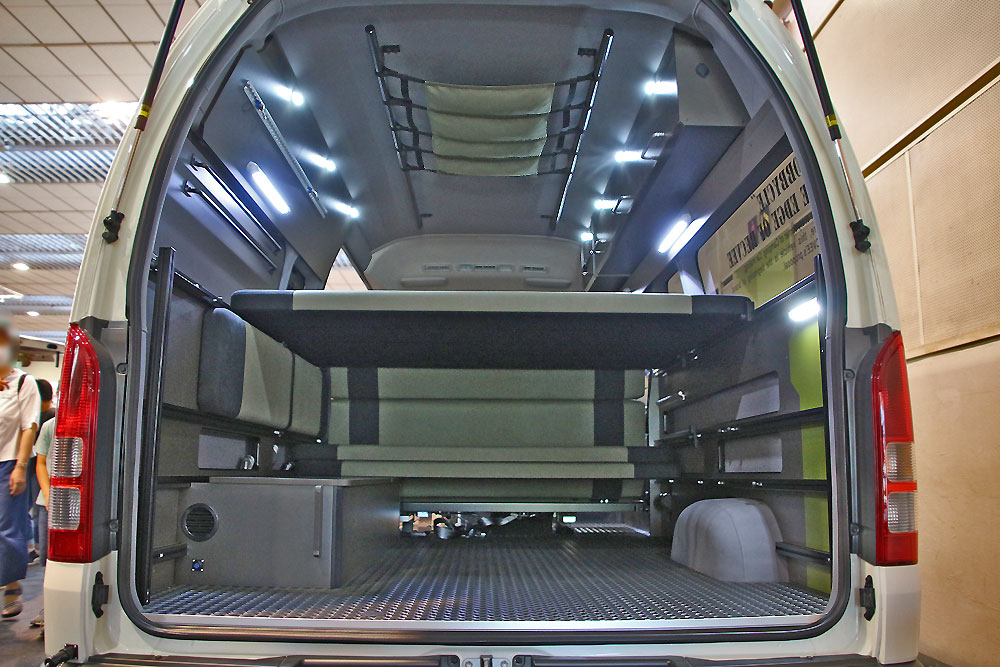 広い車内は、リアセクションがアレンジしやすいベッドシステムで構成されている。吊り棚、車体右側の天井のオーバーヘッド・シェルフ、足元のキャビネットなど収納スペースは豊富だ。