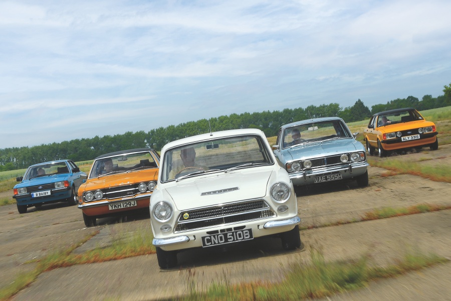 左からブルーのフォード・コルティナ・クルセイダー（Mk5）、オレンジのフォード・コルティナ 2000GXL（Mk3）、ホワイトのロータス・コルティナ（Mk1）、ライトブルーのフォード・コルティナ（Mk2）、オレンジのフォード・コルティナ 2.3S（Mk4）