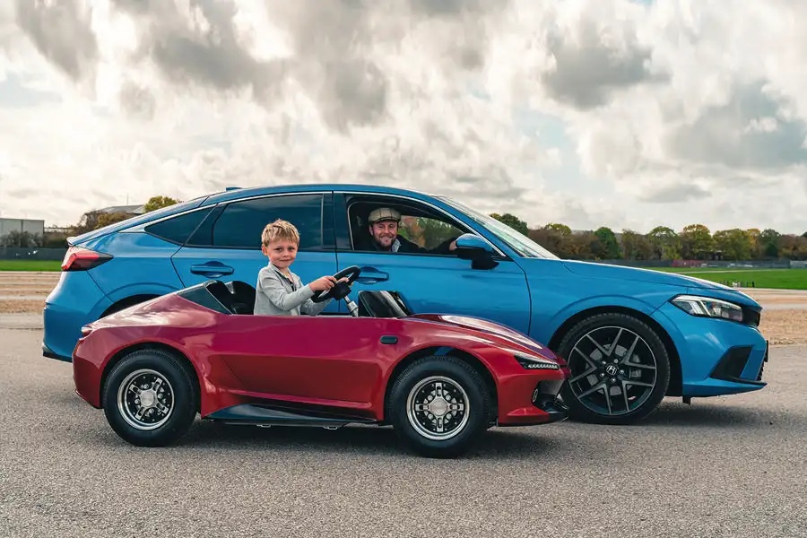 レッドのファイアフライ・スポーツと、ブルーのホンダ・シビック 2.0 i-MMD e:HEV アドバンス、それに乗る筆者と息子