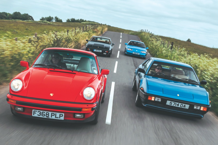 手前からレッドのポルシェ911 カレラ3.2と、ブルーのフェラーリ・モンディアル・クアトロバルボーレ、ダークグリーンのロータス・エクセル SE、ブルーのルノー・アルピーヌ GTA V6ターボ