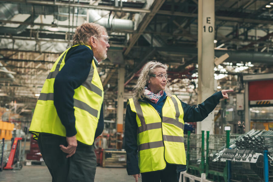 クロプリー編集長に工場を案内するミラー氏（右）。